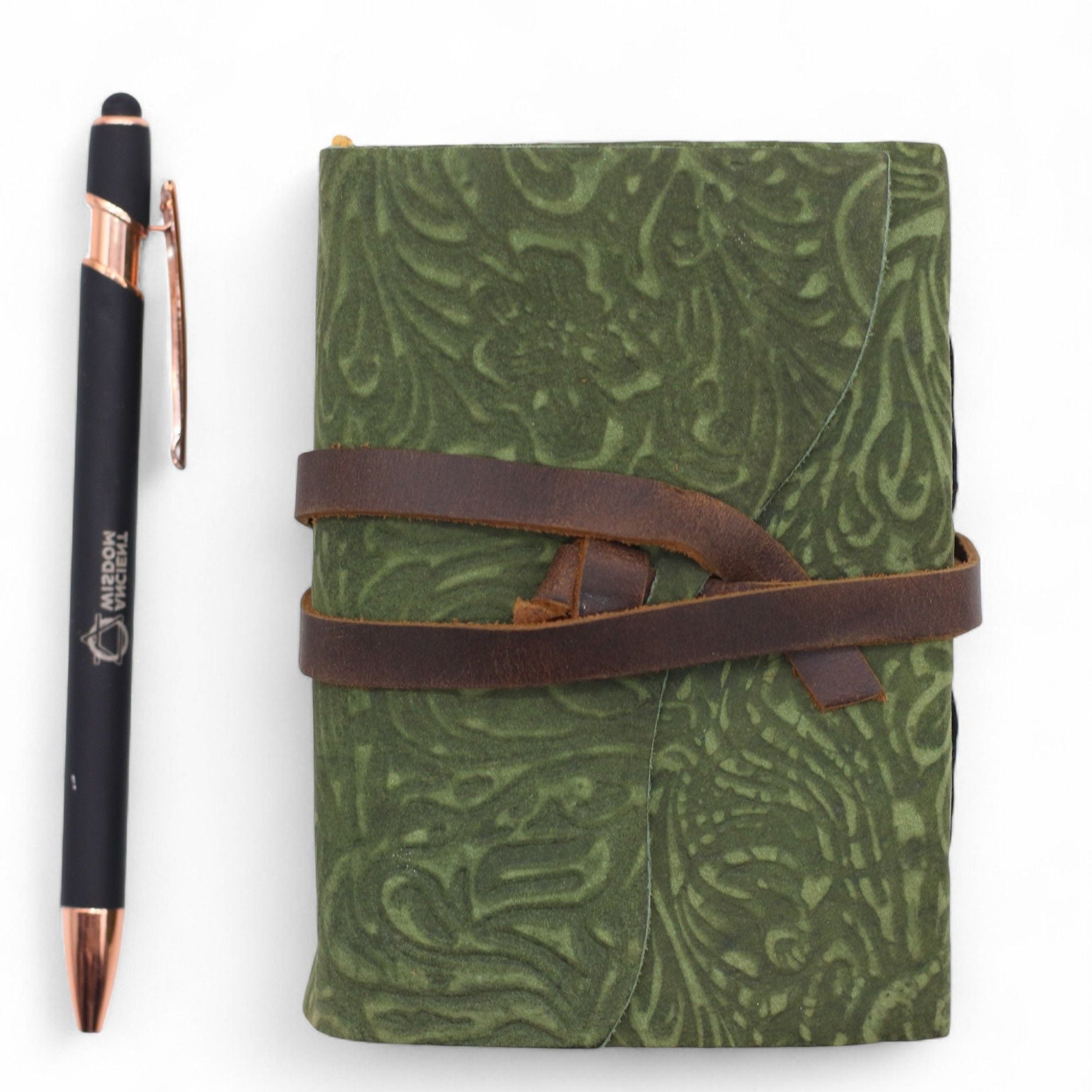 Green patterned notebook with a brown strap and a pen on a white background