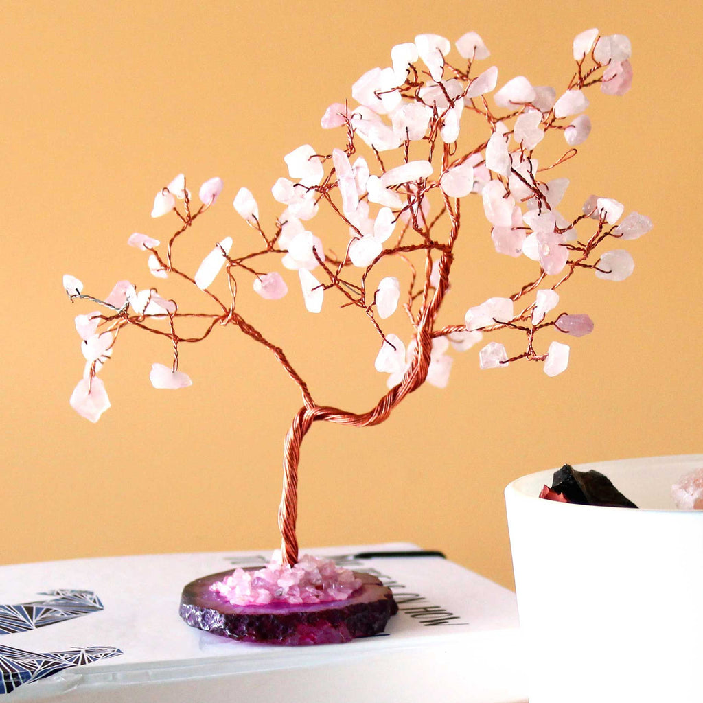 Decorative tree with pink blossoms on a book against a yellow background