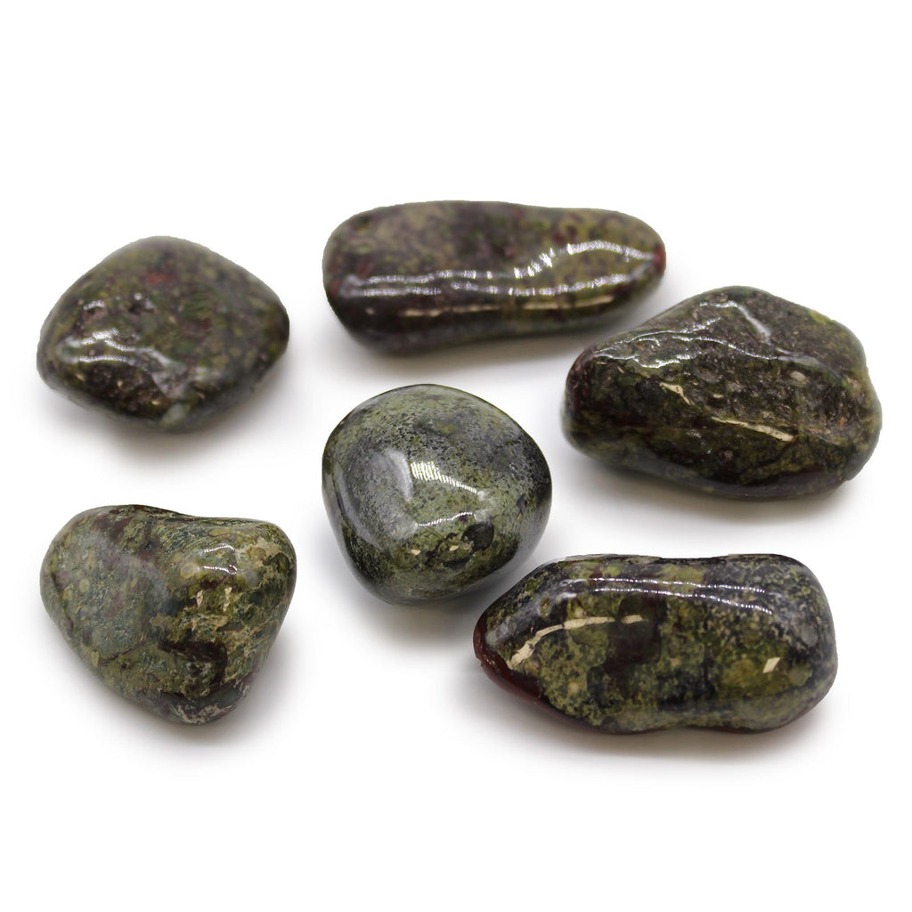 Six polished green stones on a white background