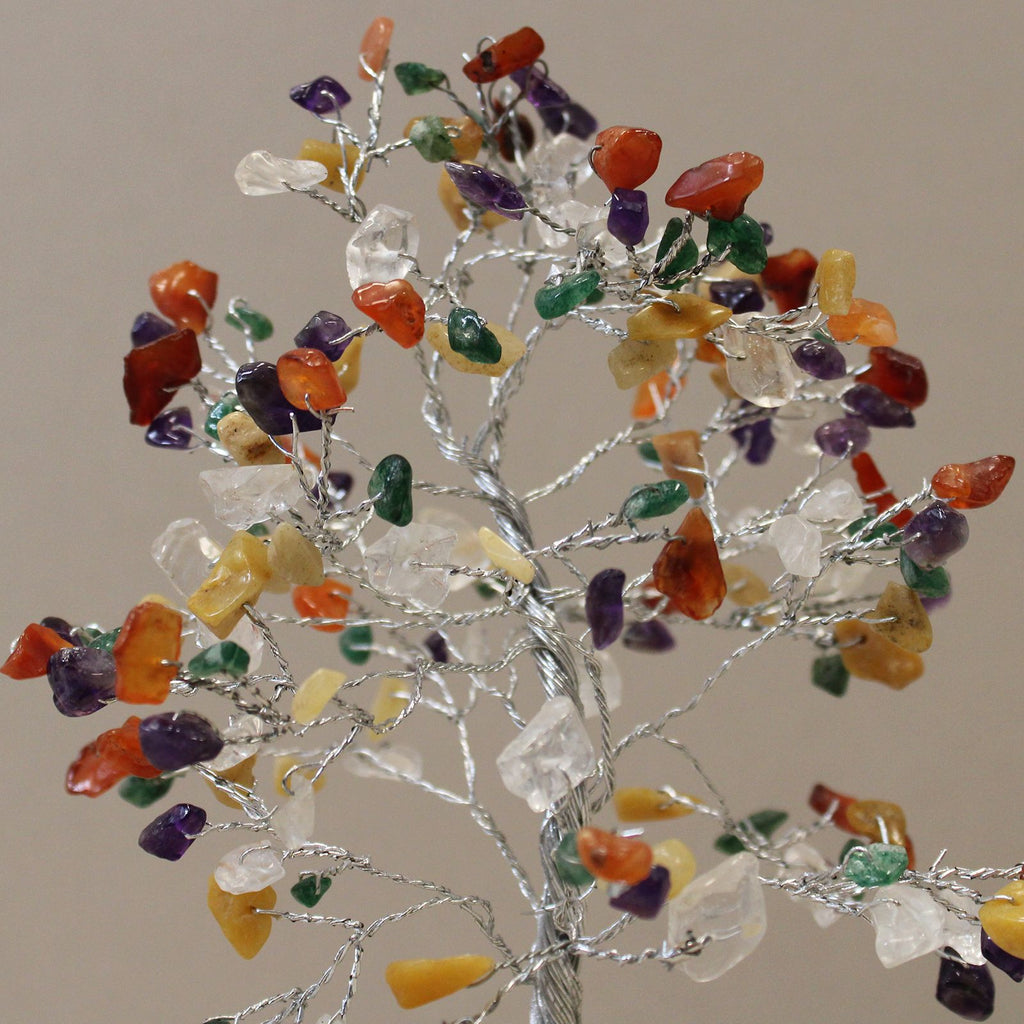 Decorative tree with multicolored stones on a plain background