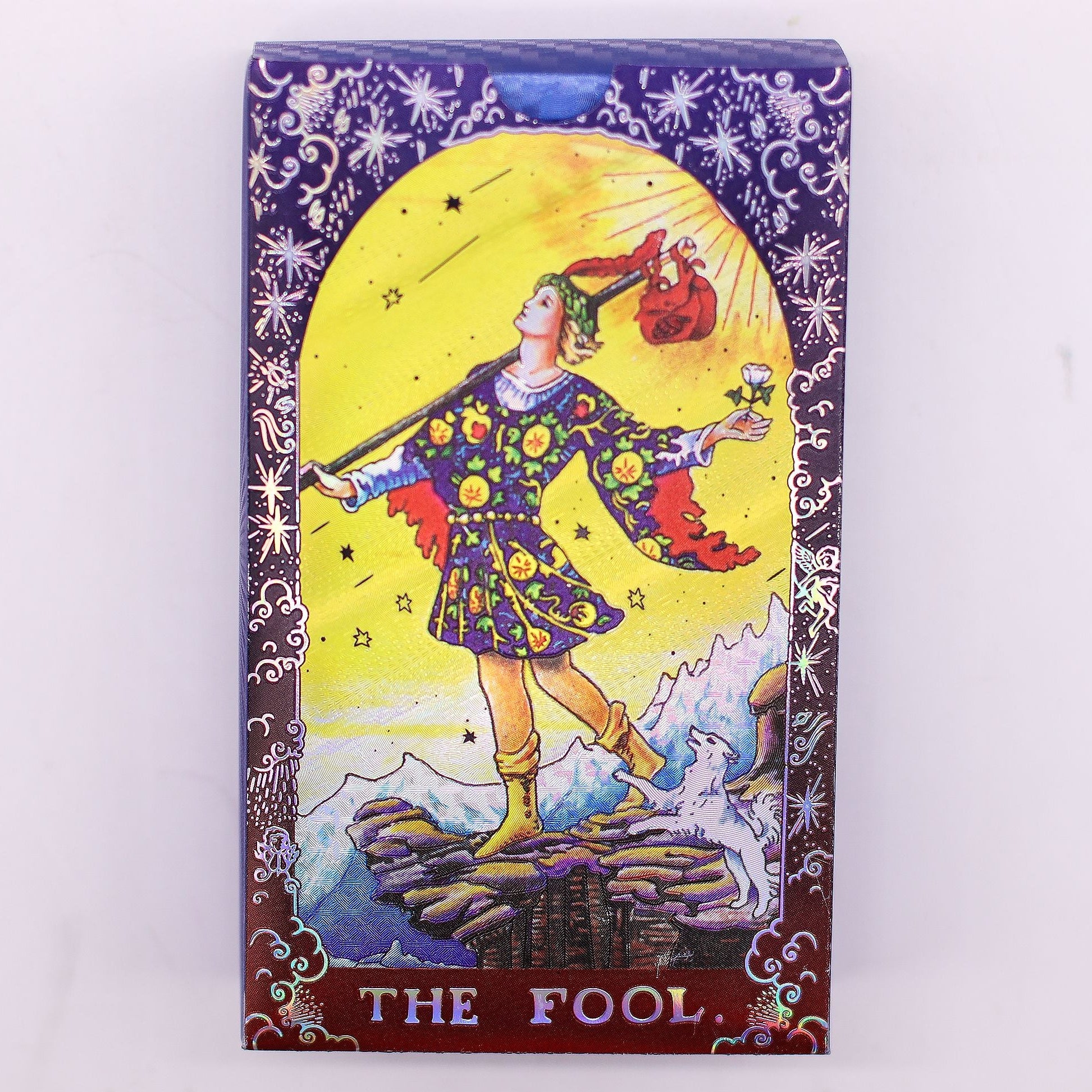 Card featuring 'The Fool' from a tarot deck with colorful illustration on a white background