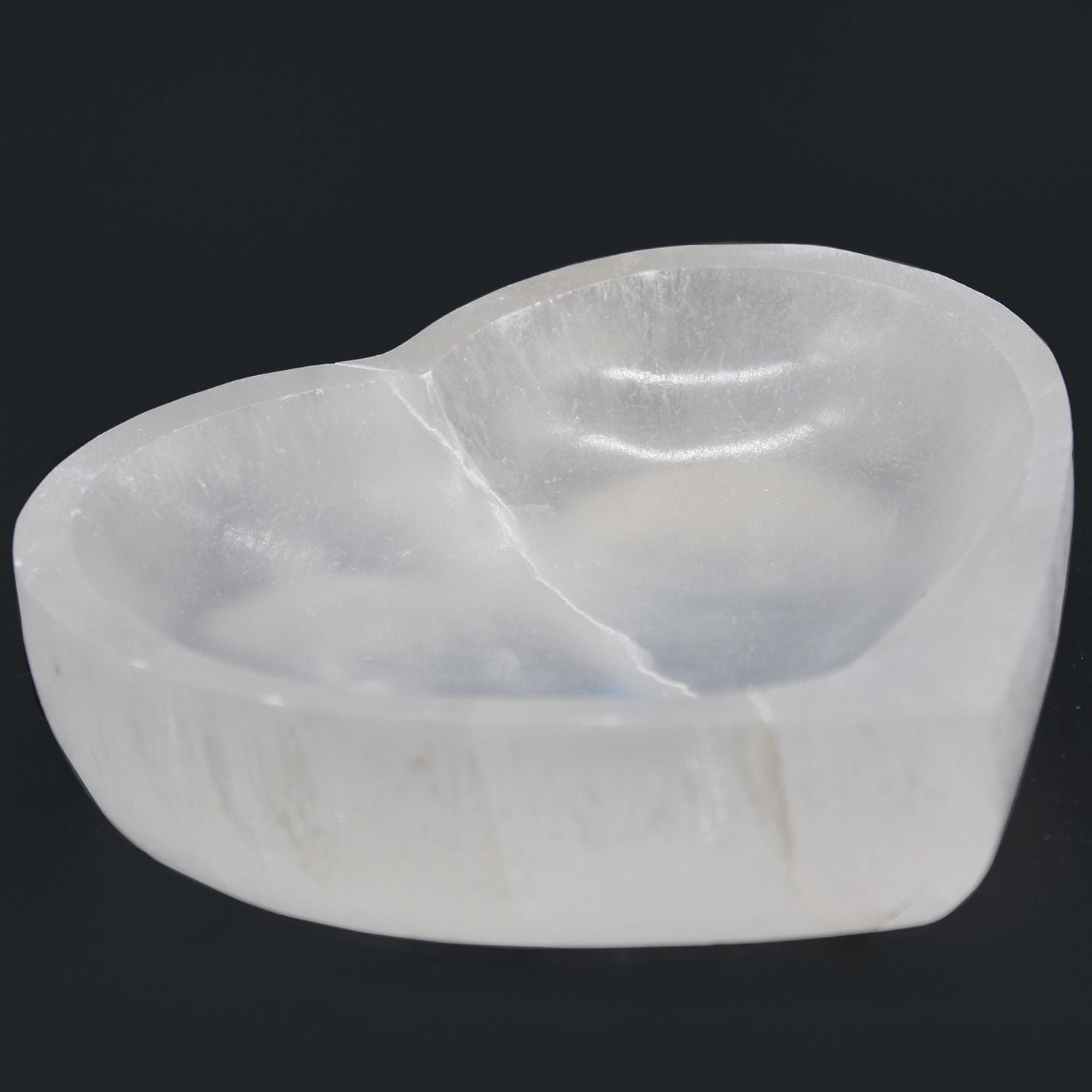 White stone with a natural, organic shape on a black background