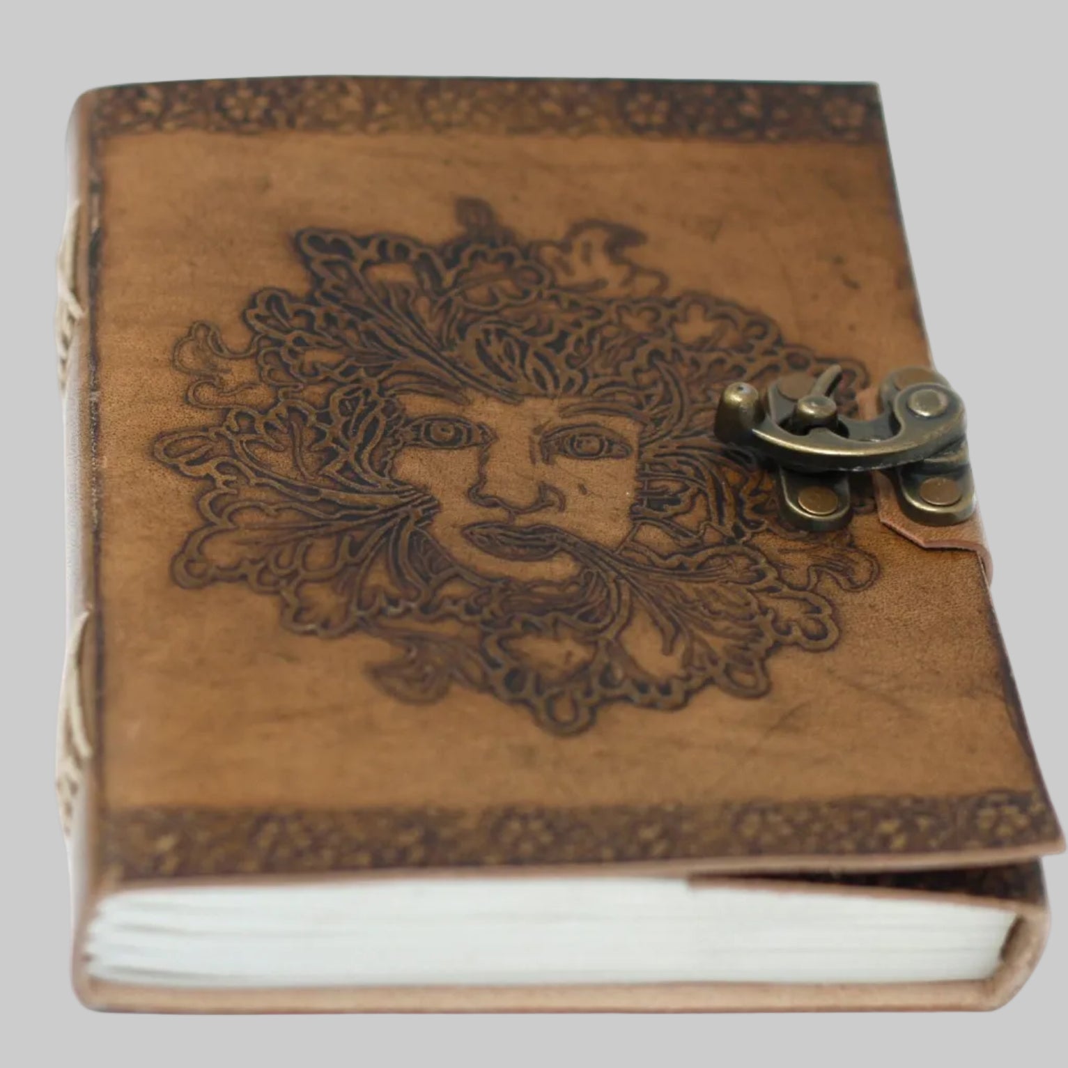 Brown leather notebook with embossed design and metal clasp on a white background