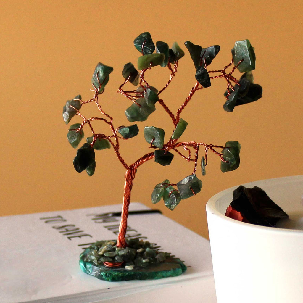 Decorative tree with green leaves on a book against an orange background