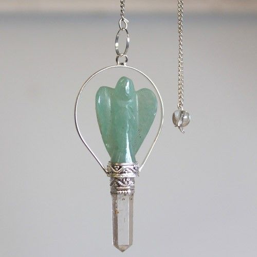 Crystal pendant with green stone and silver chain on a light gray background