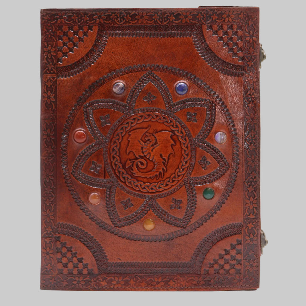 Decorative brown leather notebook with embossed design and gemstones on a white background