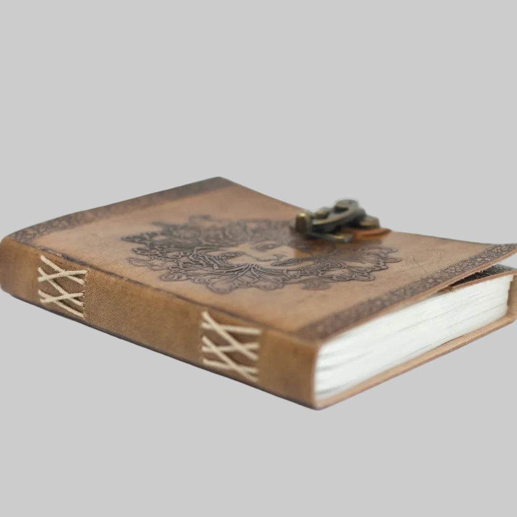 Vintage-style leather-bound notebook with decorative cover on a white background