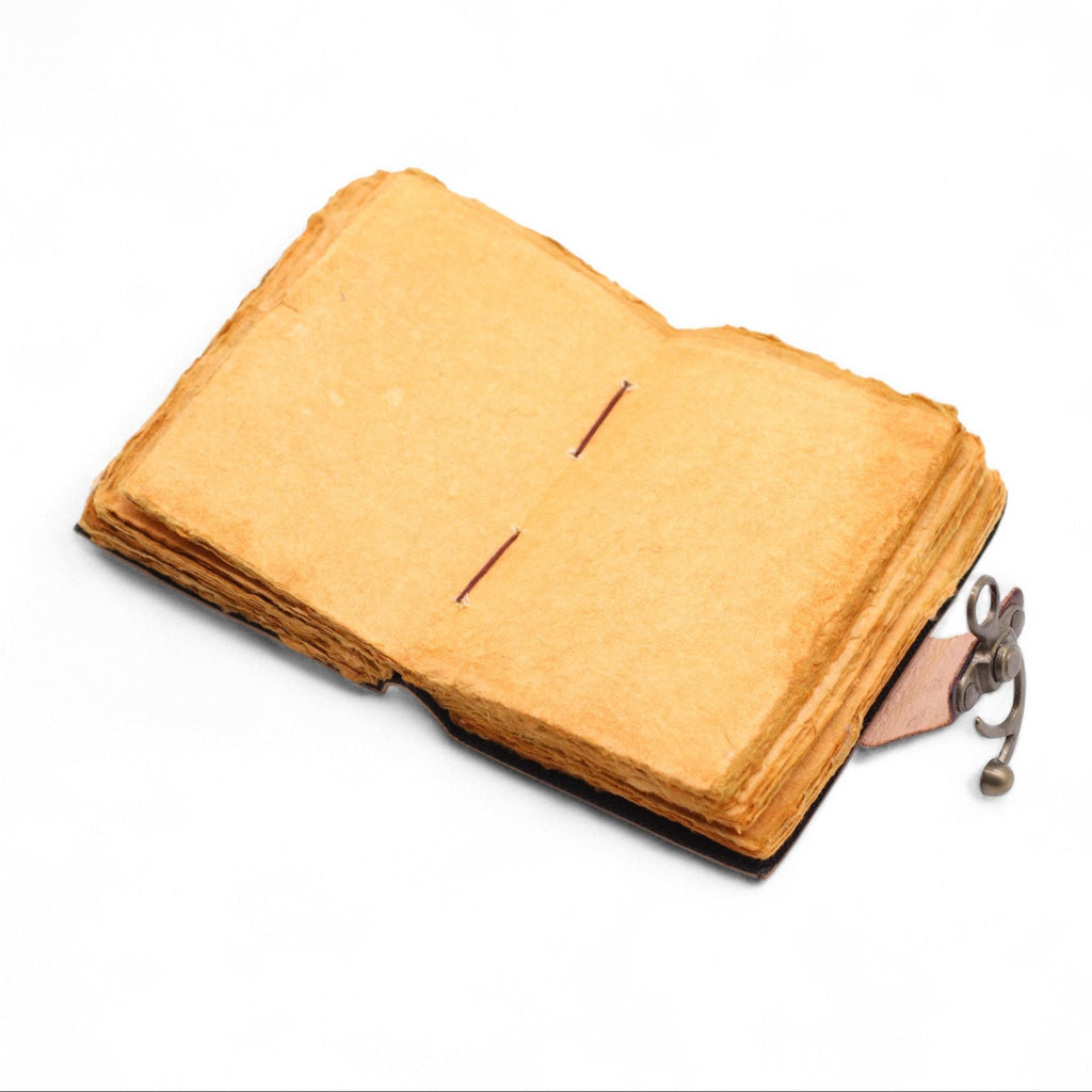 Vintage-style leather-bound notebook with a key attached on a white background