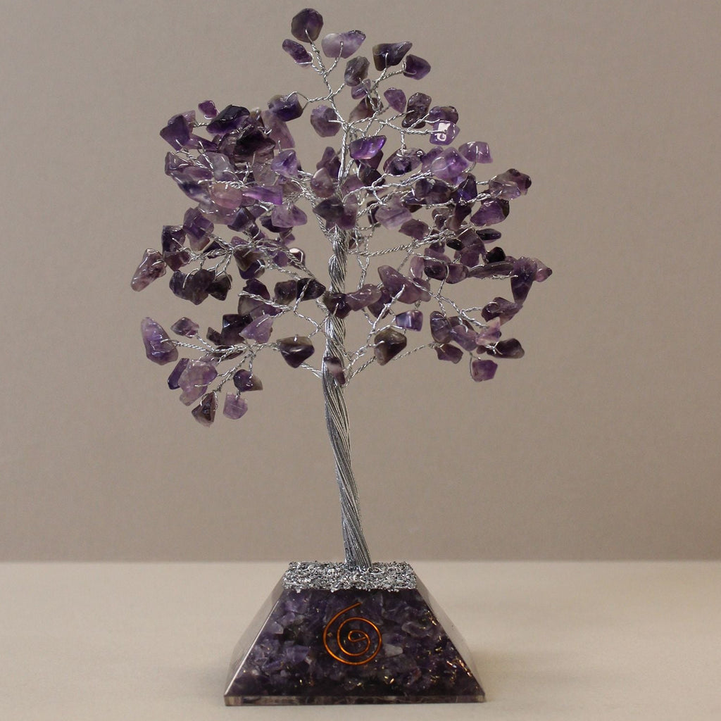 Crystal tree sculpture with purple stones on a beige background