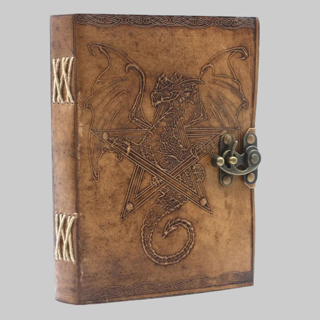 Decorative leather-bound book with dragon design and latch on a white background