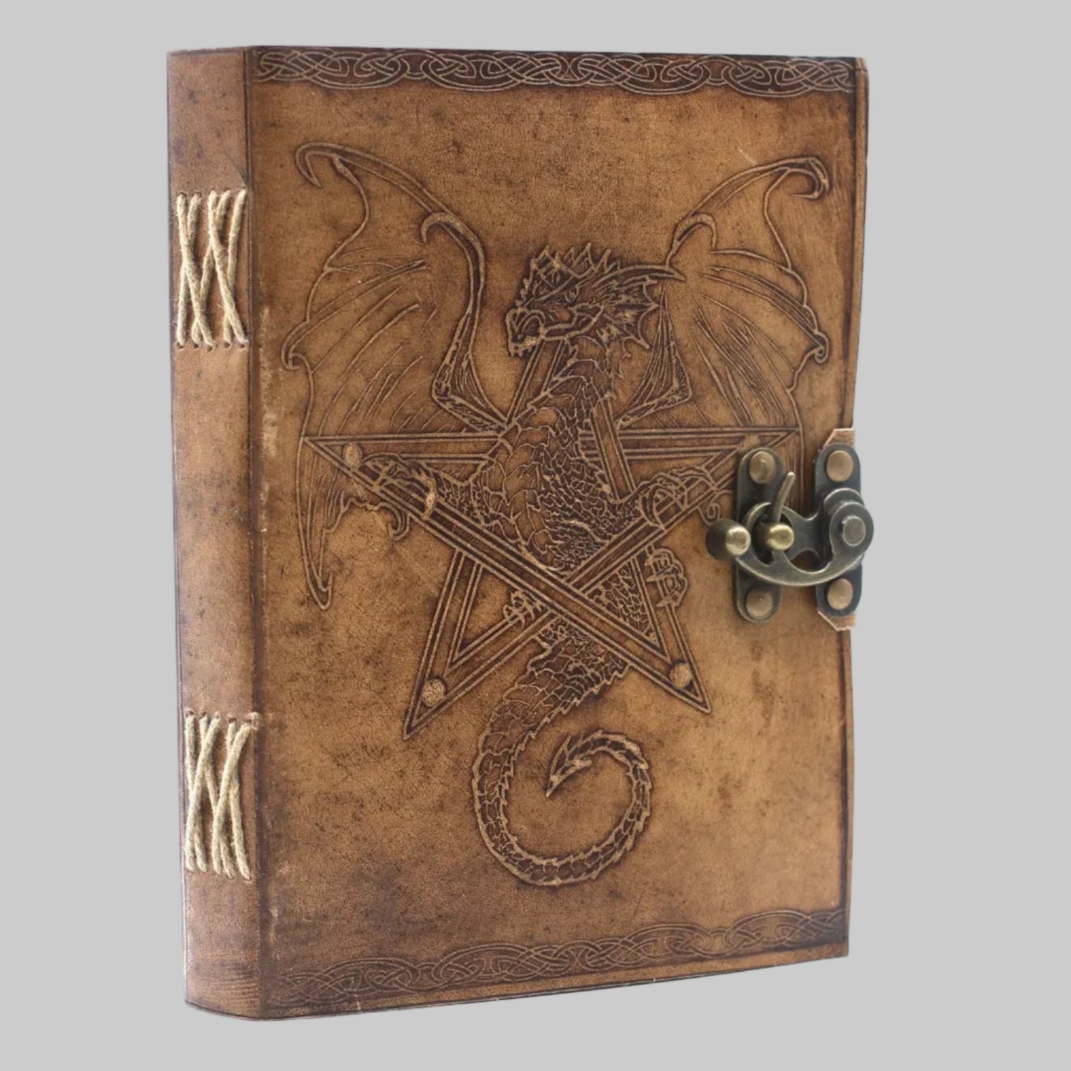Decorative leather-bound book with dragon design and latch on a white background