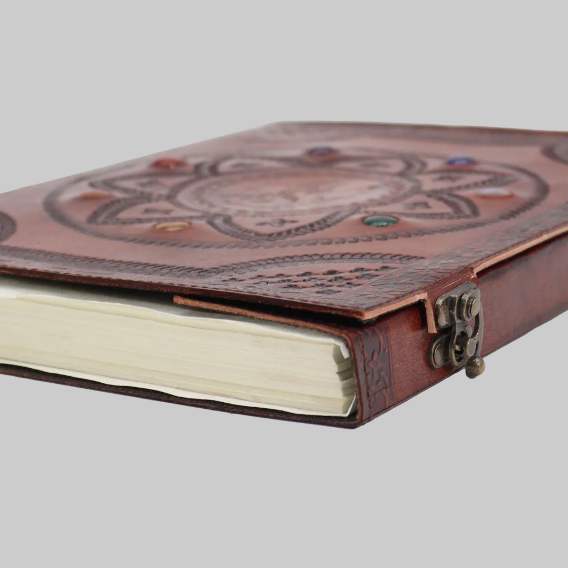 Brown leather notebook with intricate design on a white background