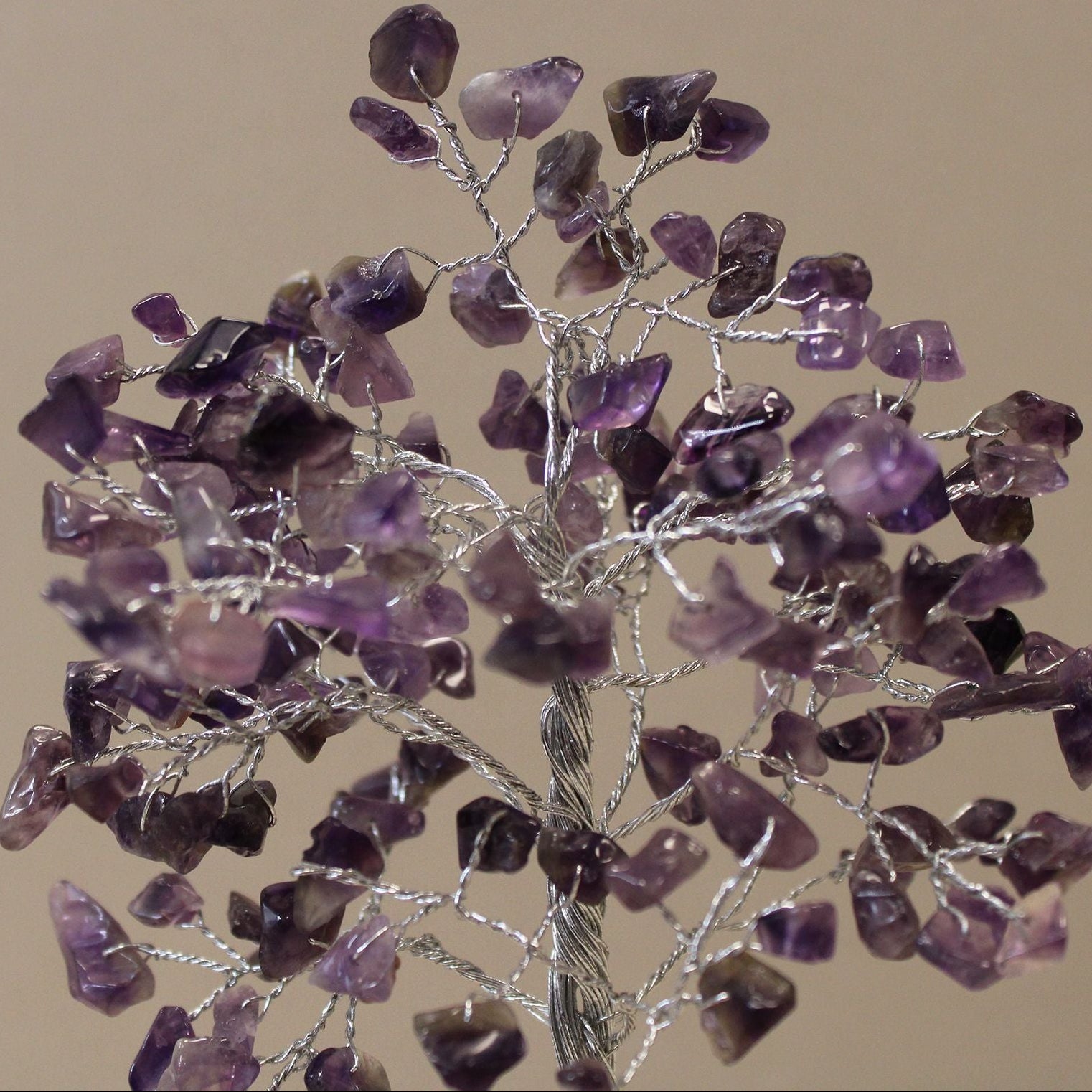 Decorative tree made of purple stones on a beige background