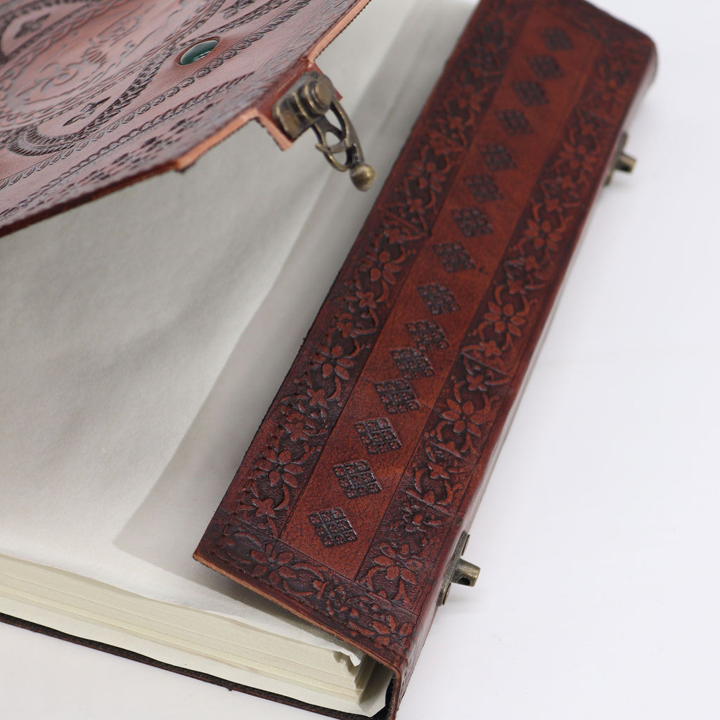 Close-up of a leather-bound book with intricate designs on a white background