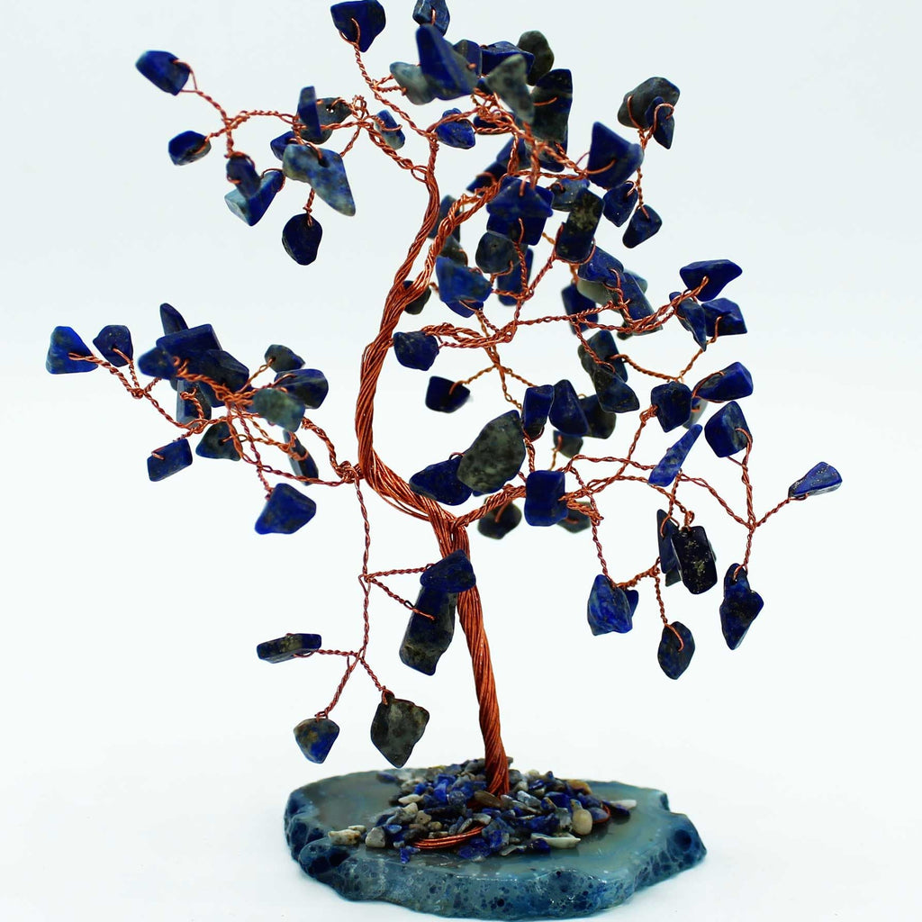 Decorative tree sculpture with blue stones on a white background