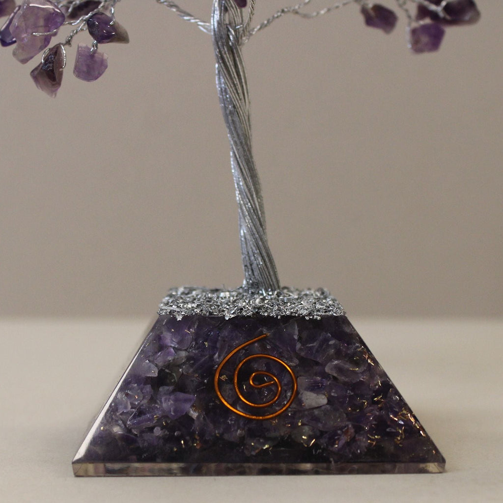 Decorative crystal pyramid with purple stones on a beige background