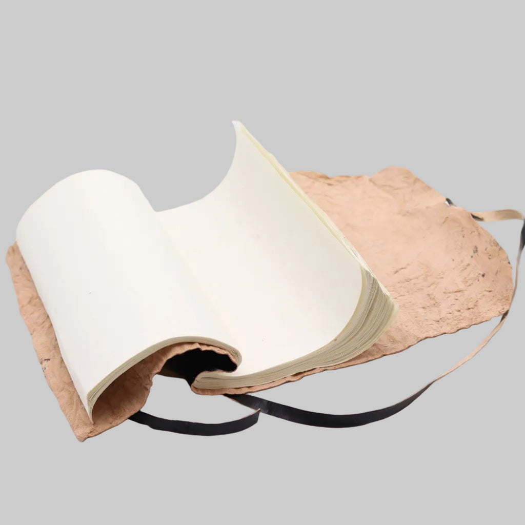 Open book with beige cover and black strap on a white background
