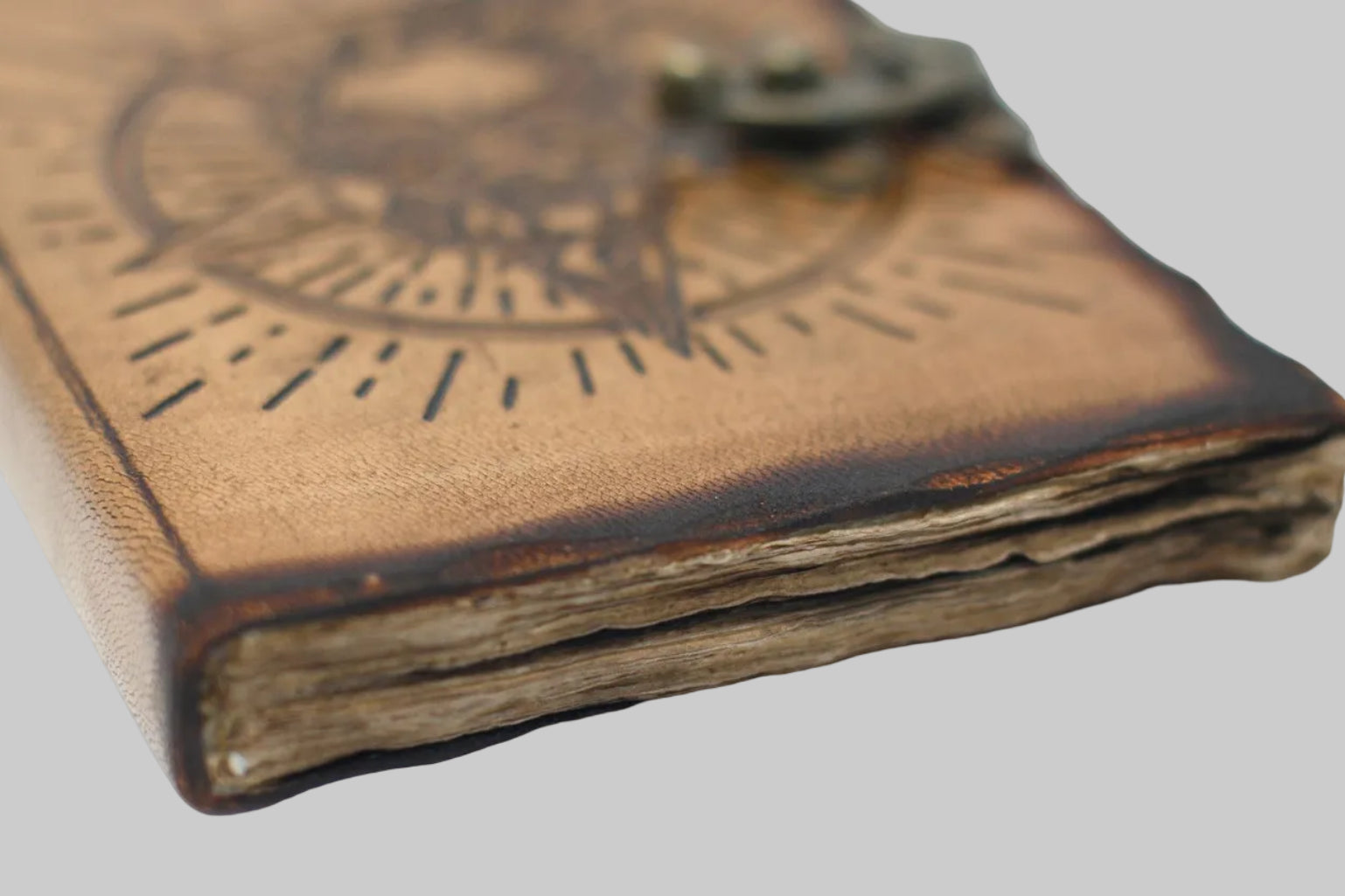 Close-up of a leather-bound book with engraved design on a white background
