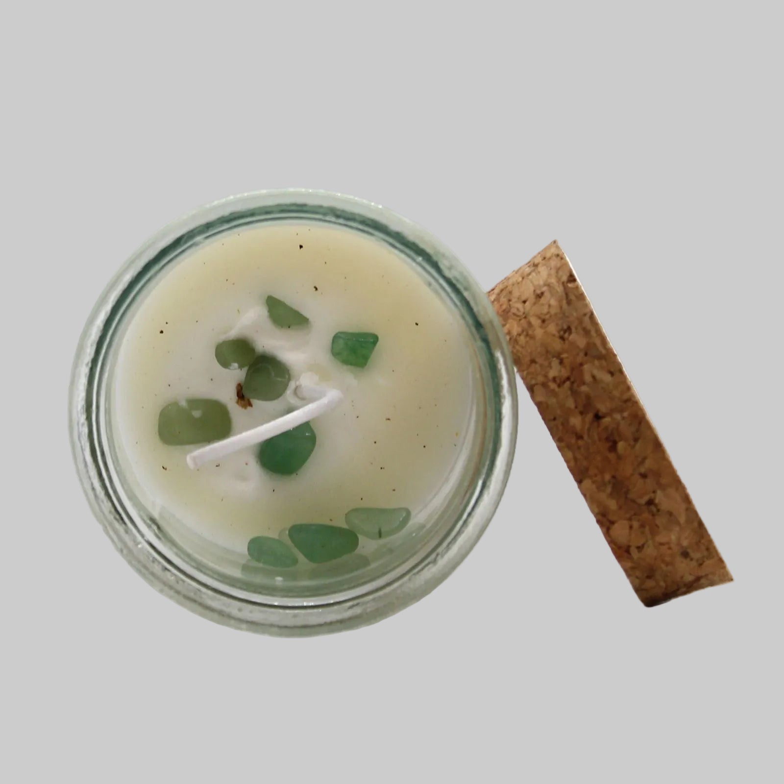 Candle in a glass jar with a cork lid on a white background