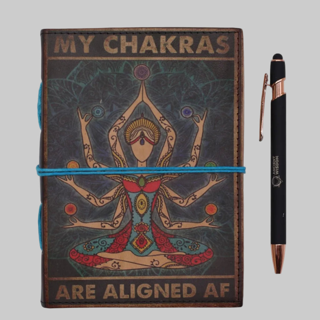 Notebook titled 'My Chakras Are Aligned AF' with a pen on a white background