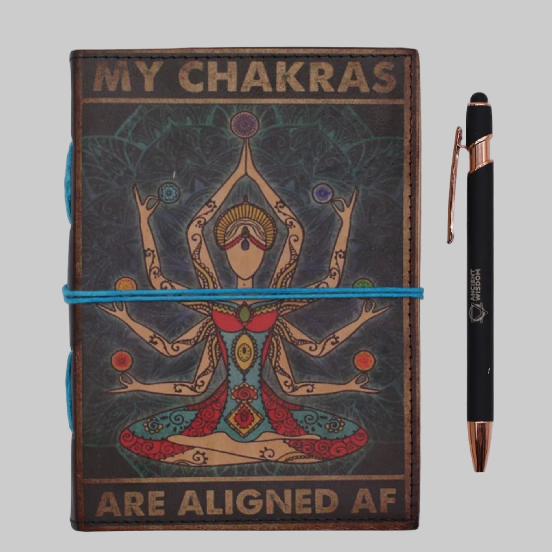 Notebook titled 'My Chakras Are Aligned AF' with a pen on a white background