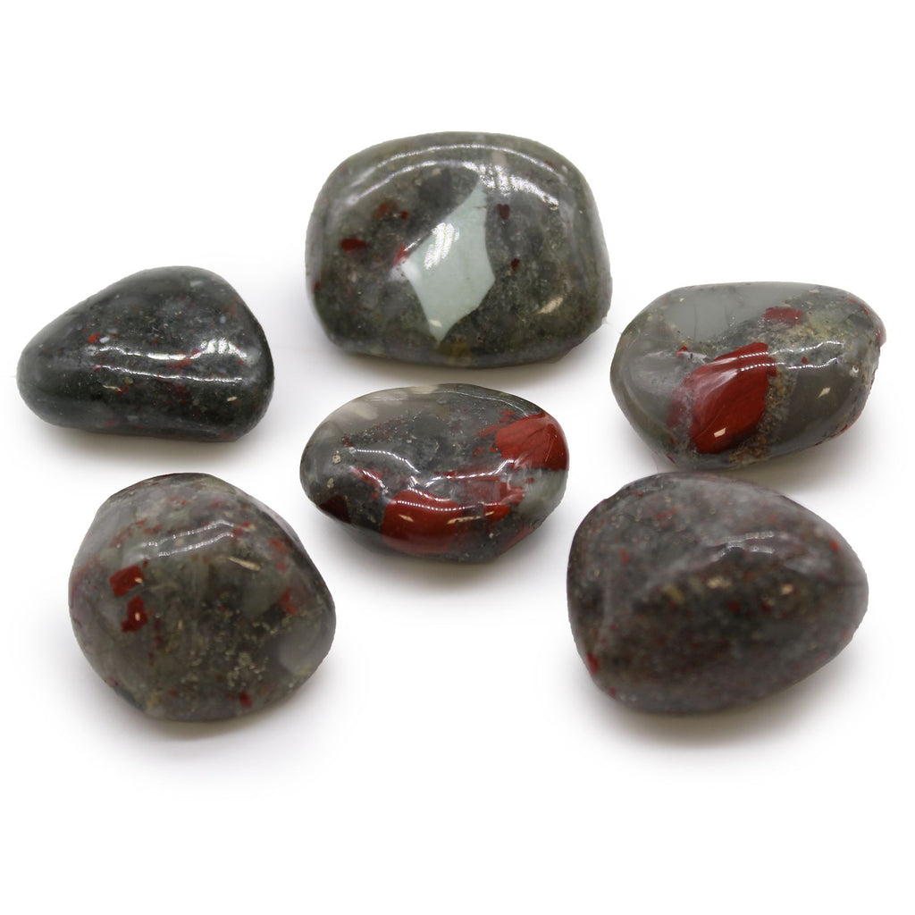 Six polished stones with red and white inclusions on a white background