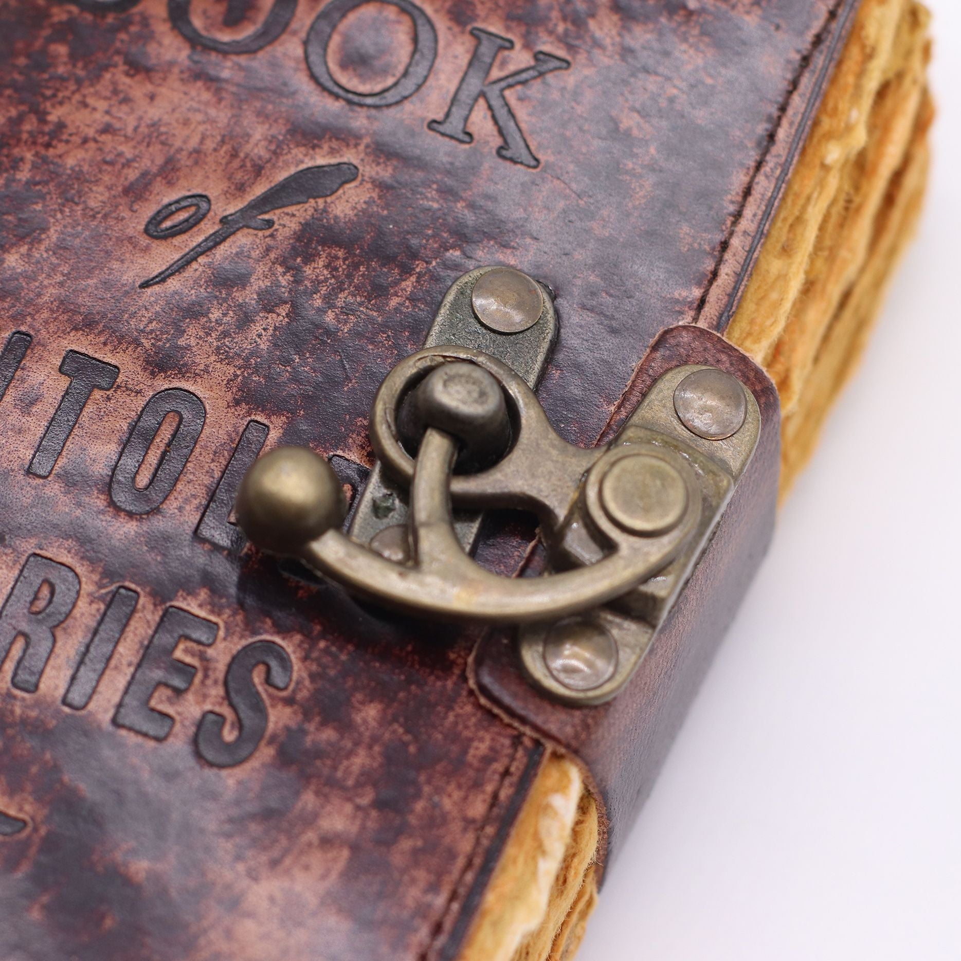 Close-up of a leather-bound book with embossed text and a metal clasp.