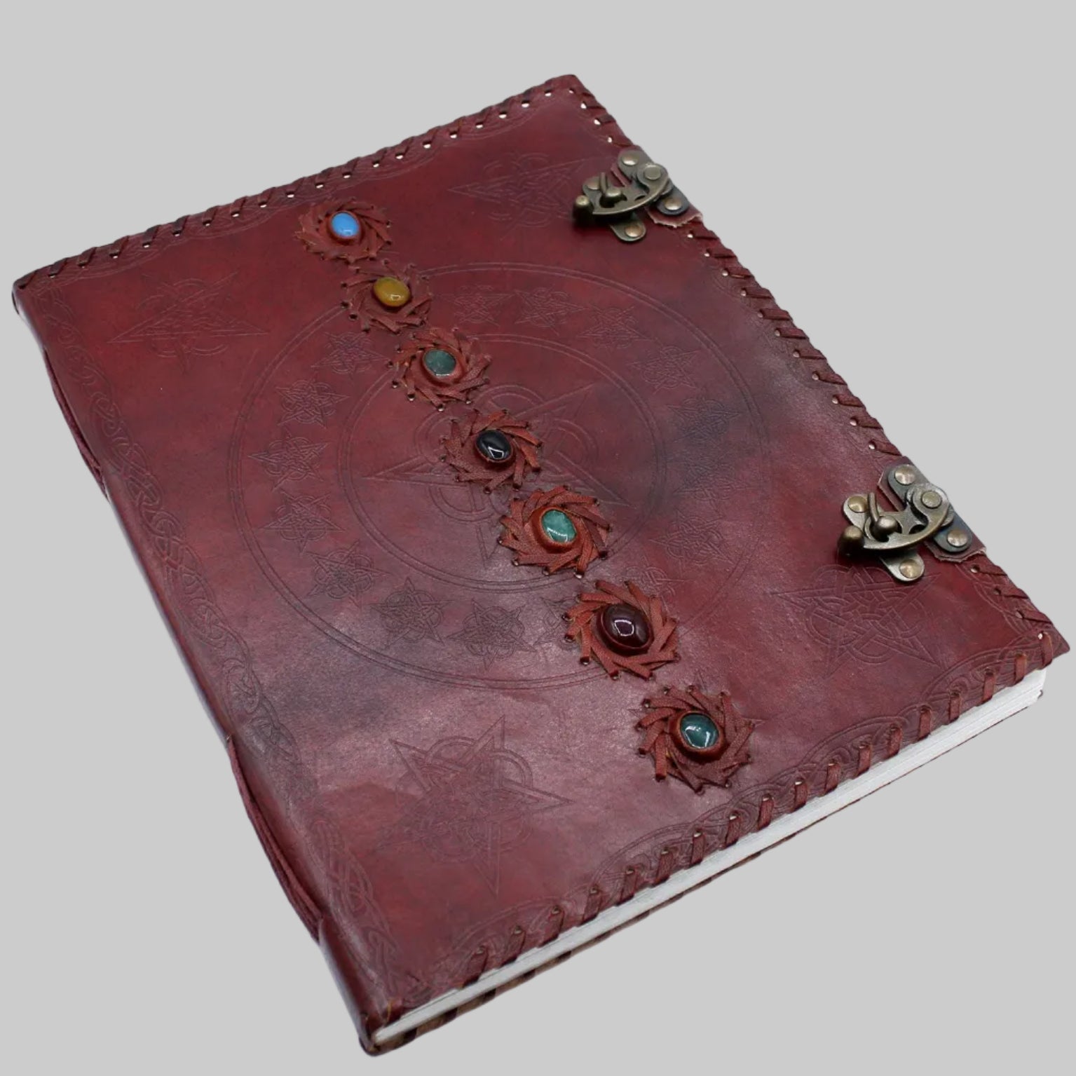 Red leather journal with decorative elements on a white background