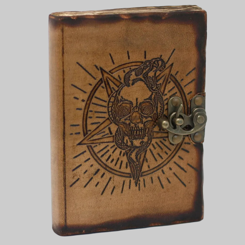 Brown leather notebook with skull and snake design on a white background