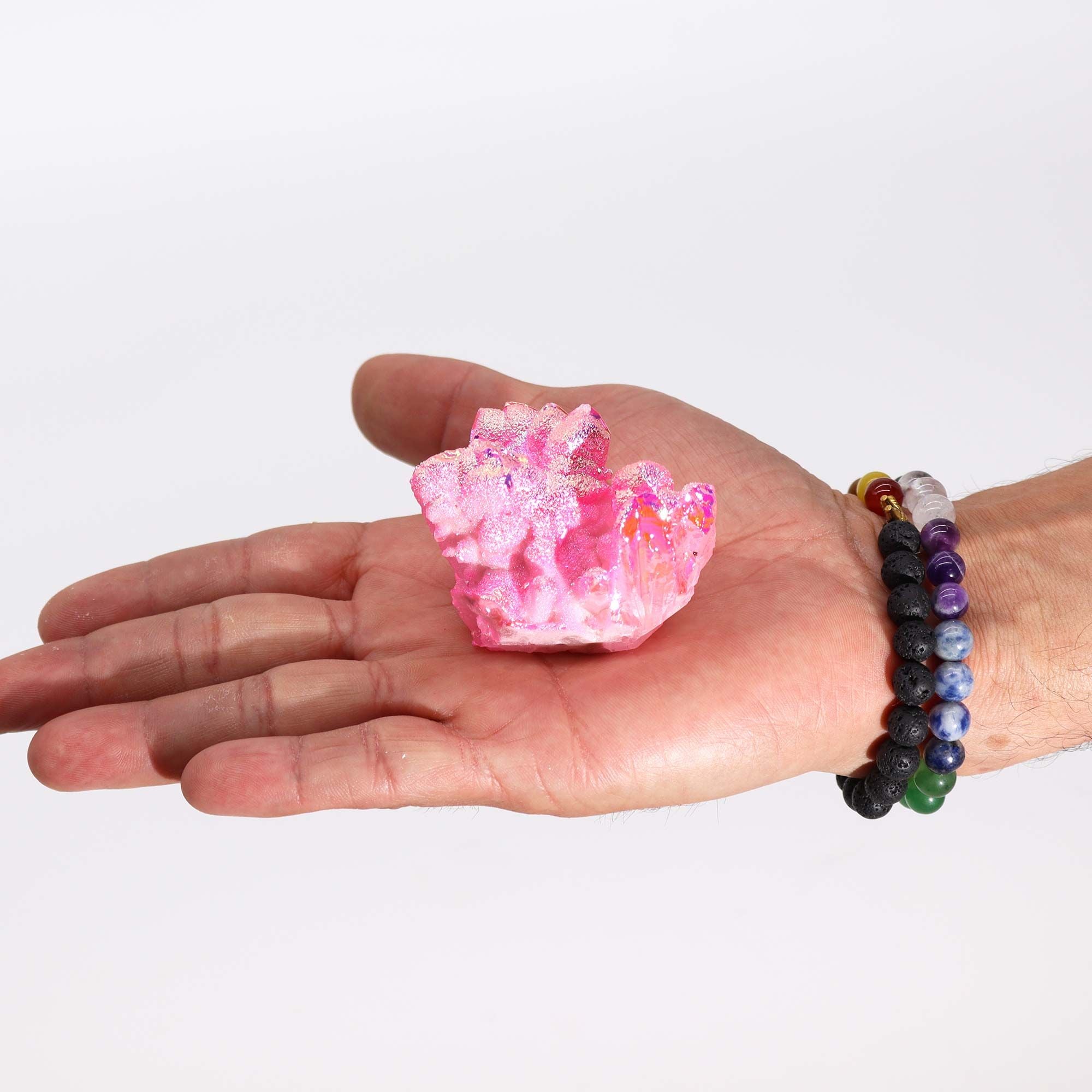 Hand holding a pink crystal on a white background