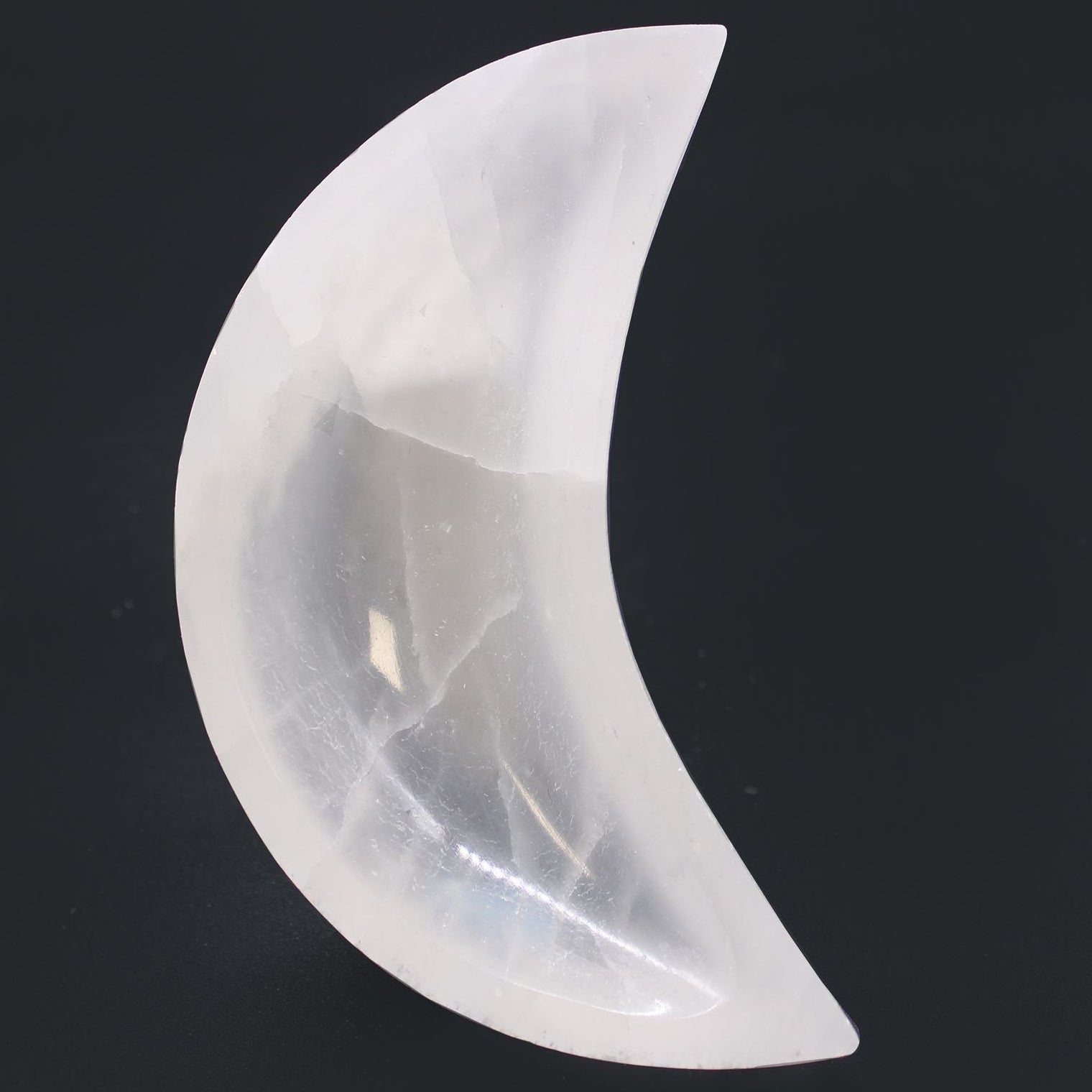 Crystal moon-shaped object on a black background