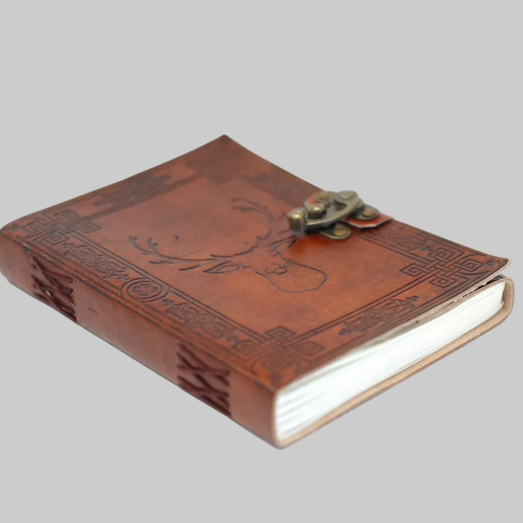 Brown leather journal with embossed design and metal clasp on a white background