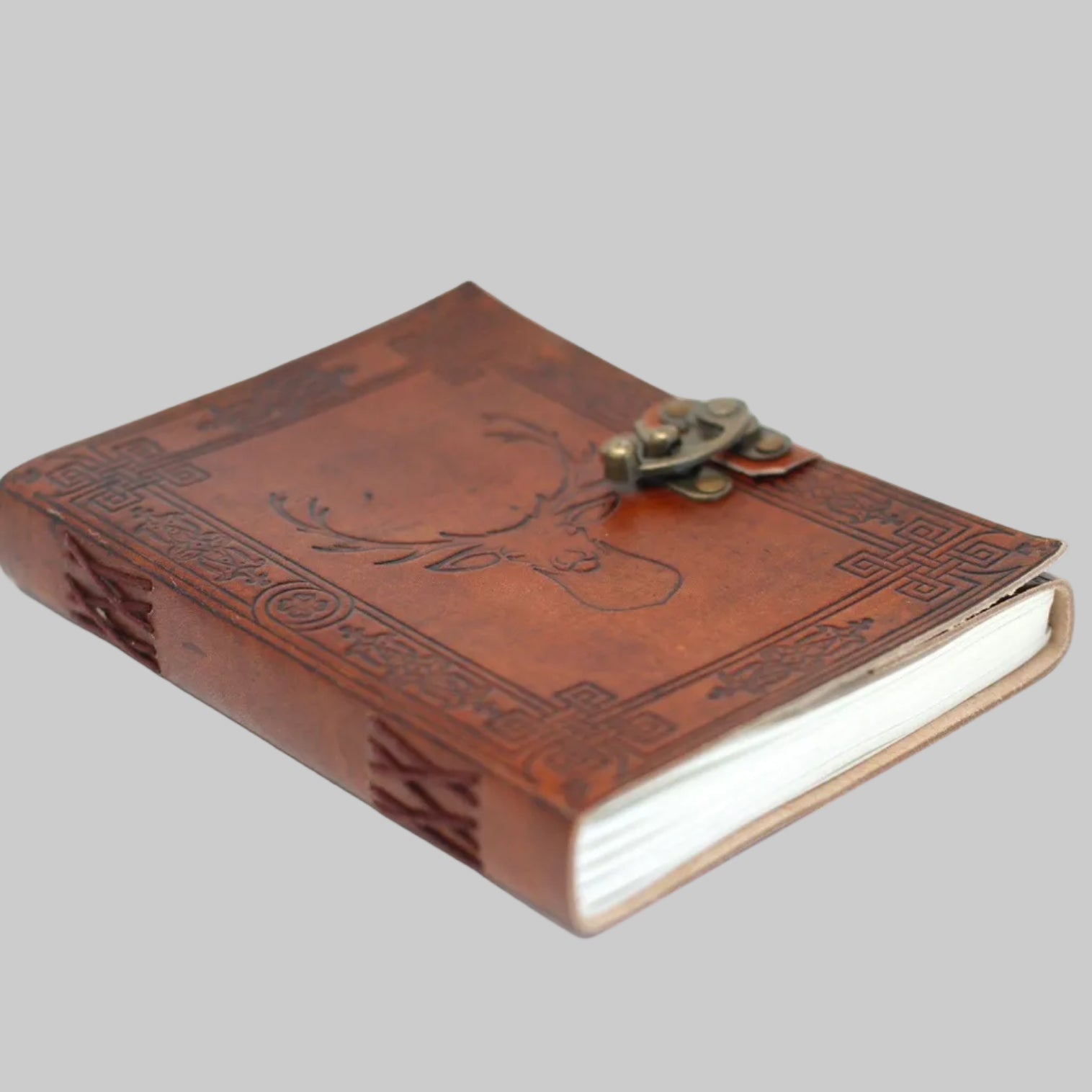 Brown leather journal with embossed design and metal clasp on a white background