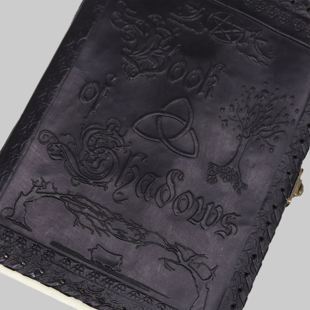 Black leather-bound book with embossed designs and text on a white background