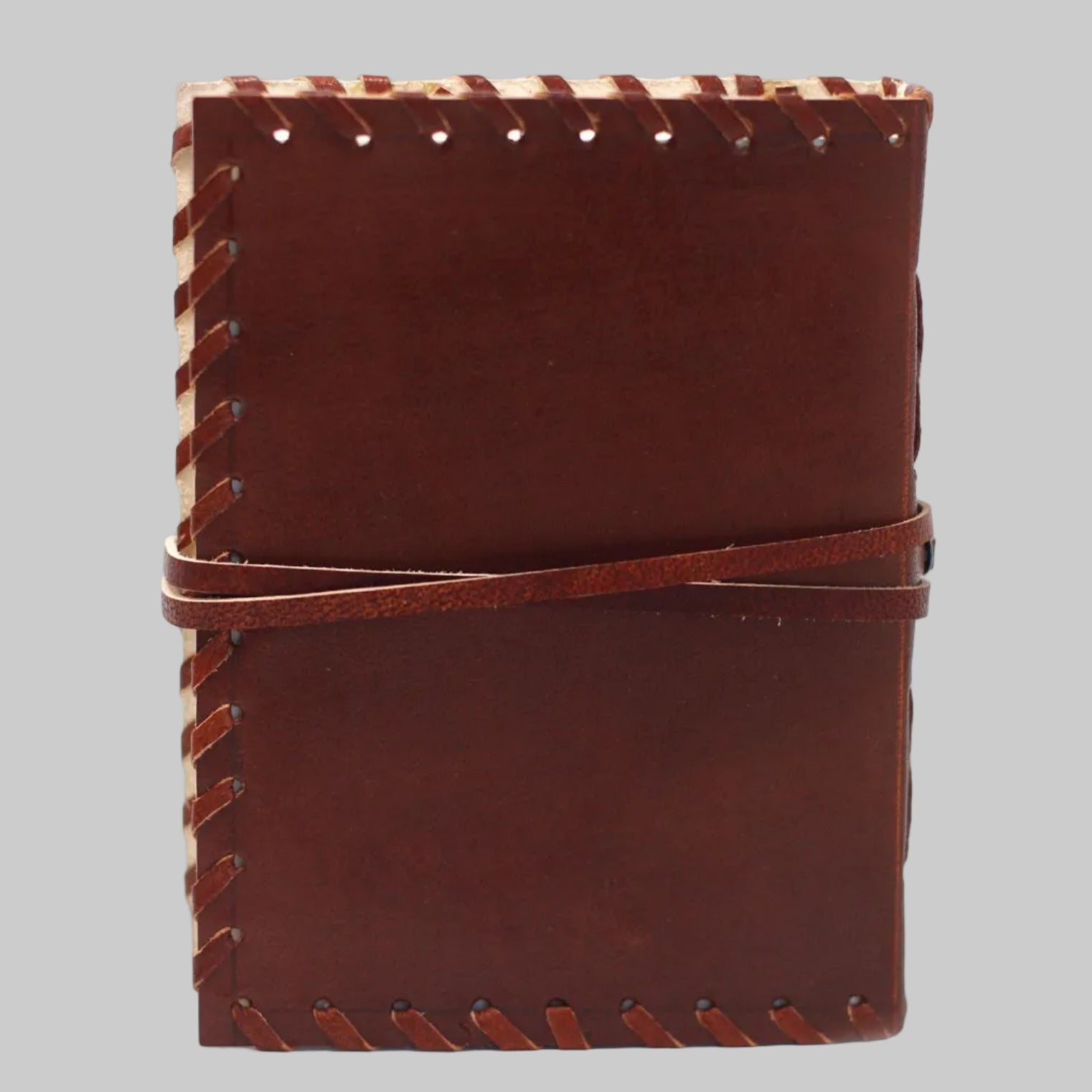 Brown leather notebook with visible stitching on a white background