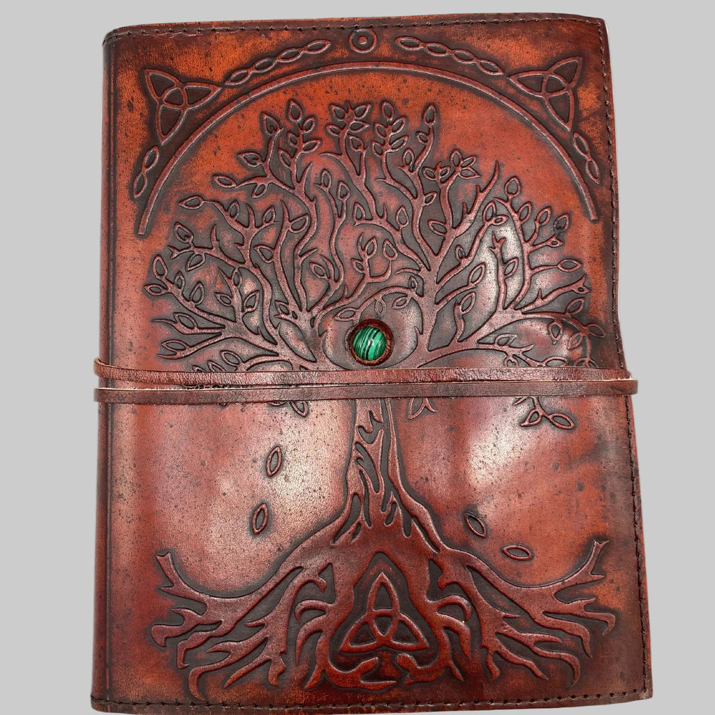 Brown leather journal with tree of life design and green gemstone on a white background