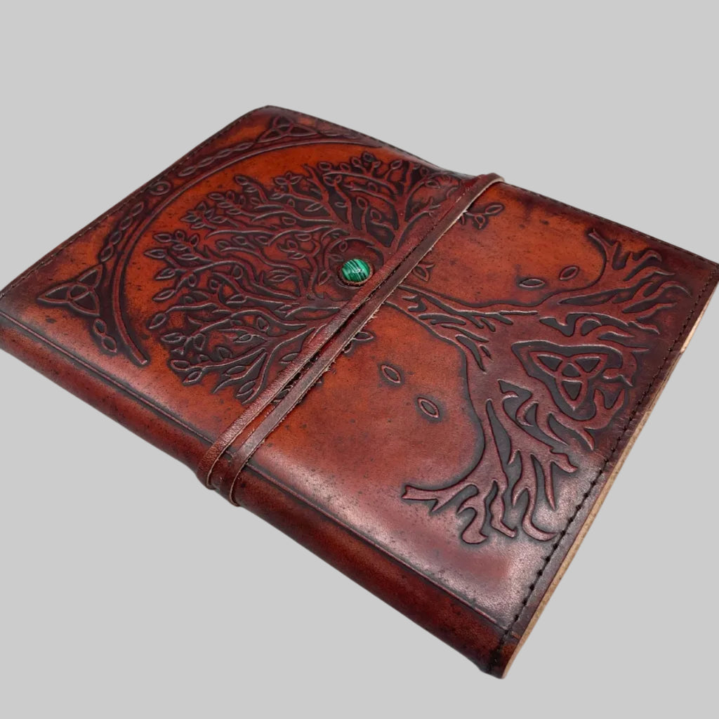 Brown leather journal with embossed design on a white background