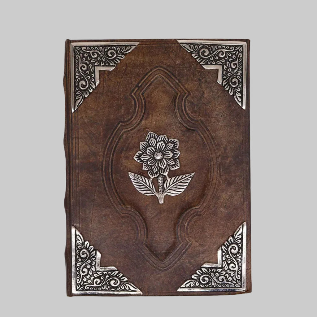 Decorative brown book with floral design and intricate patterns on a white background