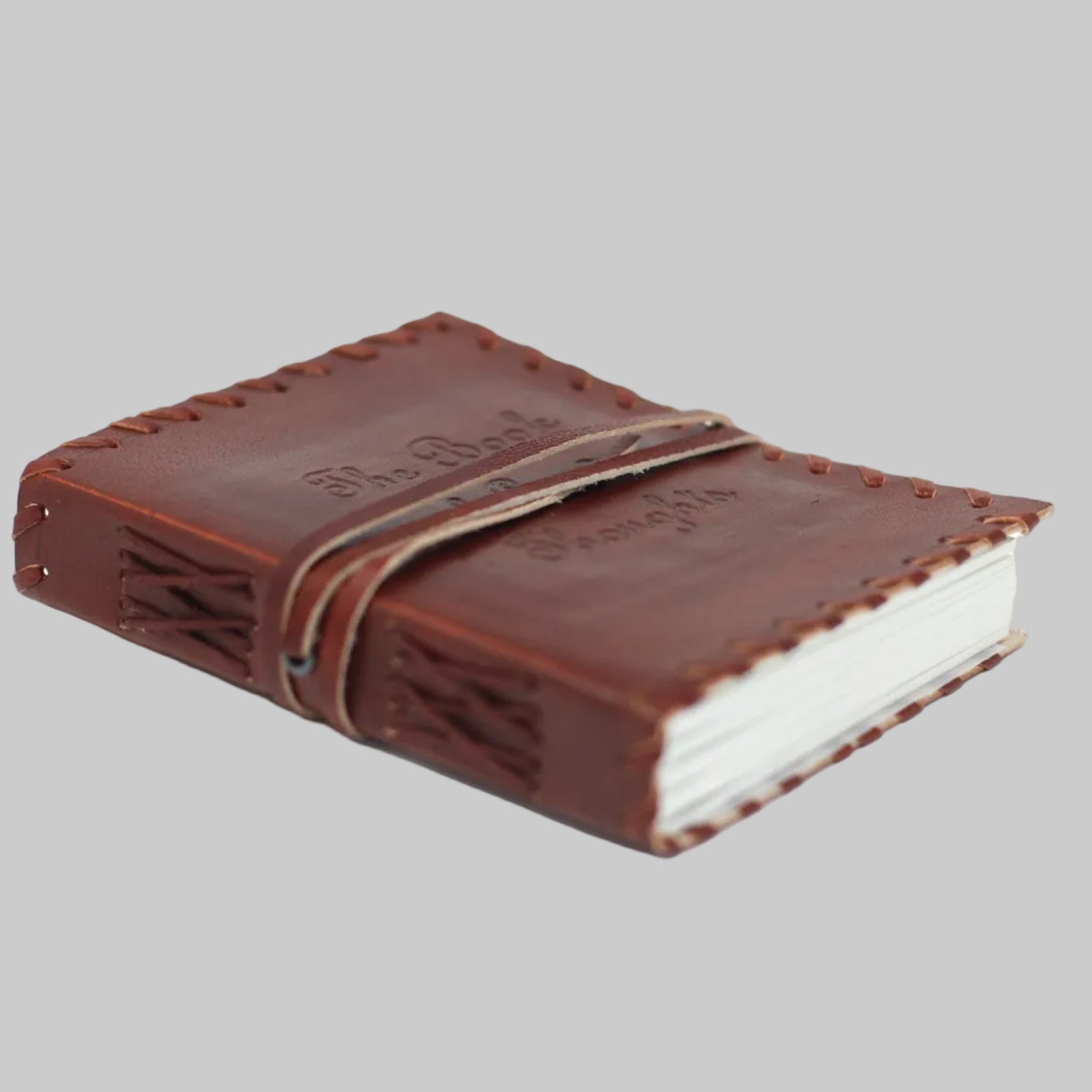 Brown leather notebook with white pages on a white background