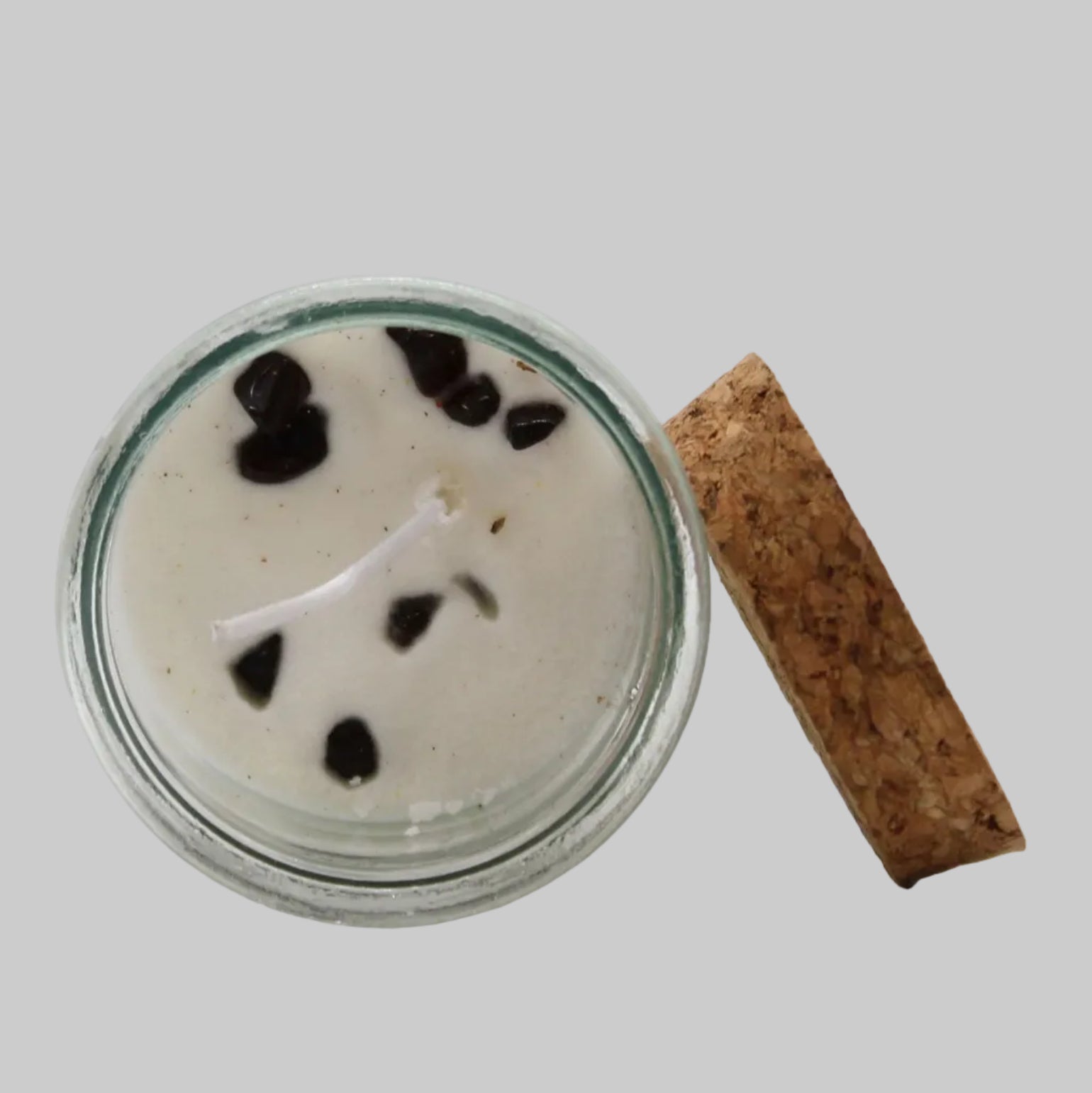 Candle in a glass jar with a cork lid on a white background