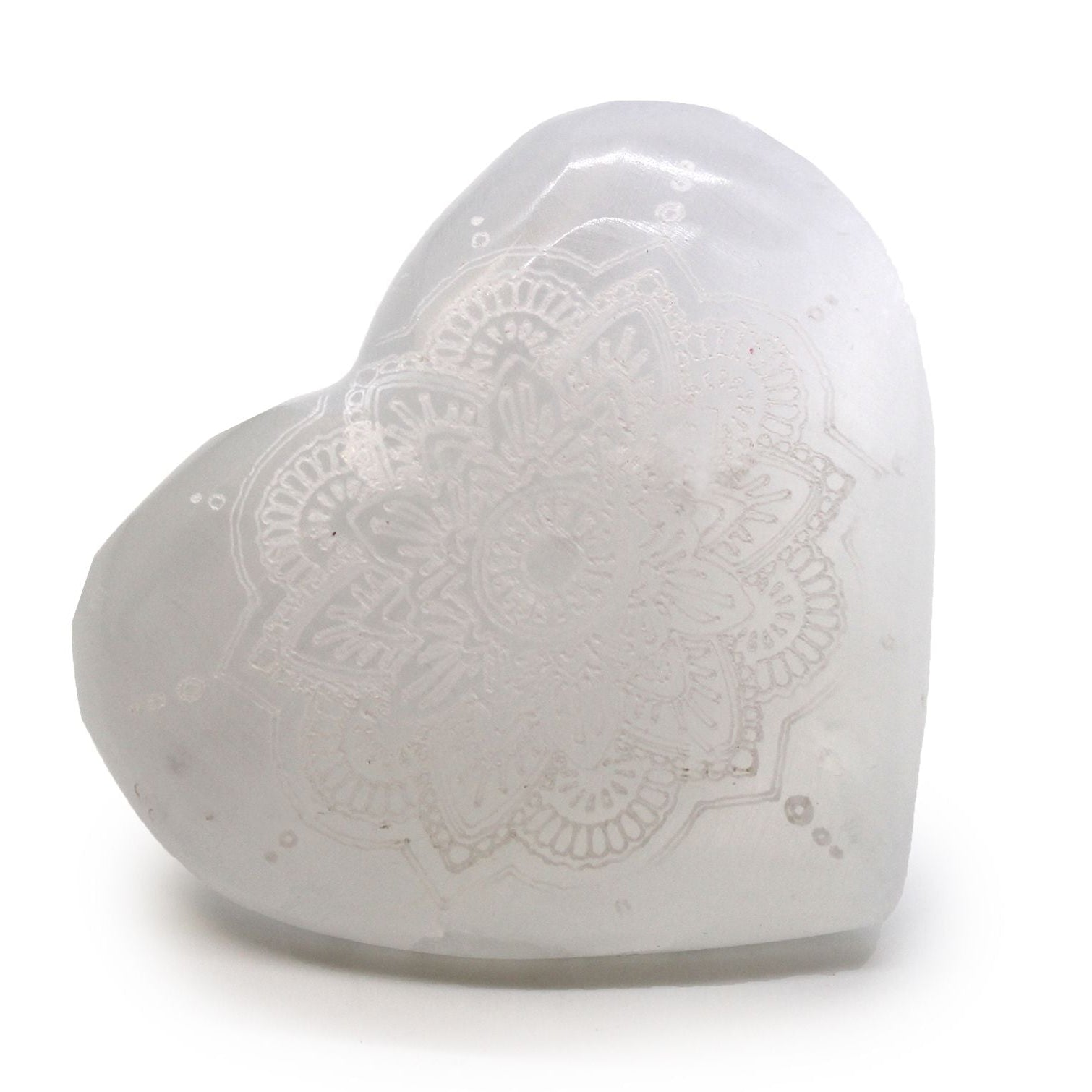 Heart-shaped white ceramic object with intricate patterns on a white background