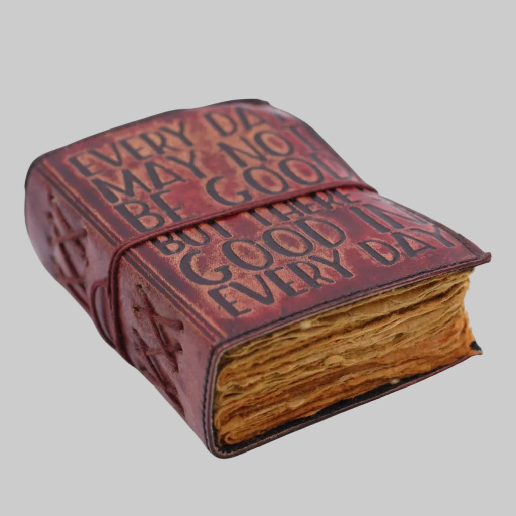 Decorative leather-bound book with embossed text on a white background