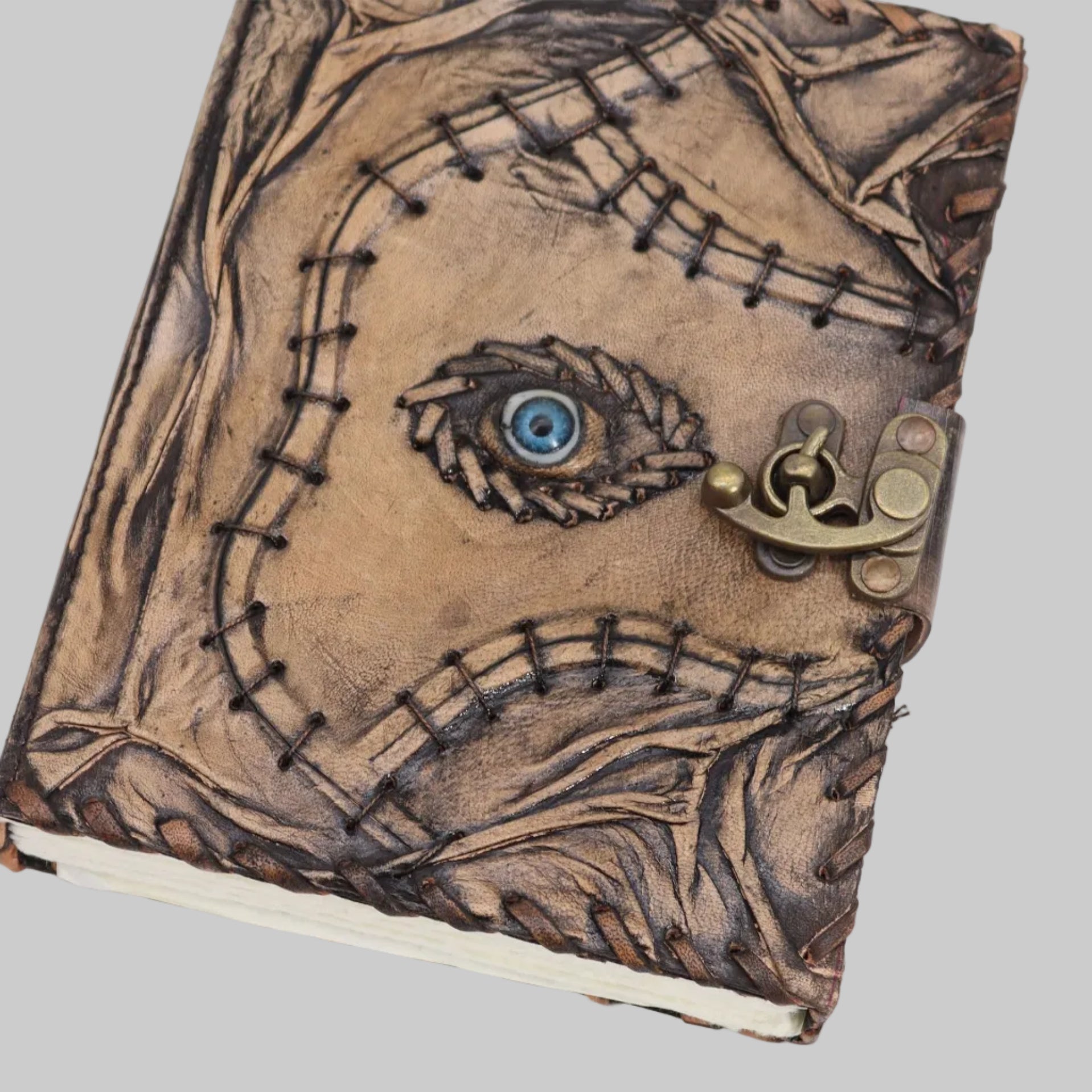 Handmade leather journal with eye design and lock on a white background