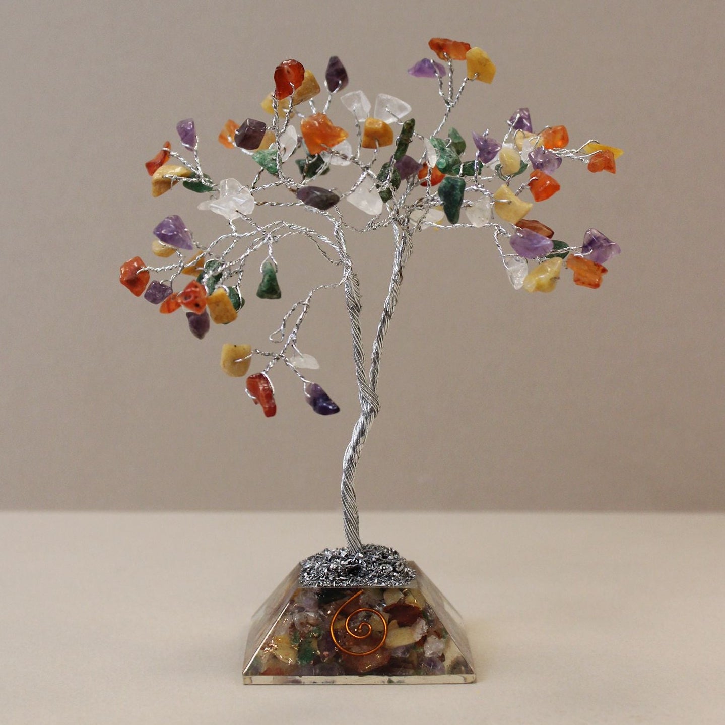 Crystal tree with multicolored stones on a beige background