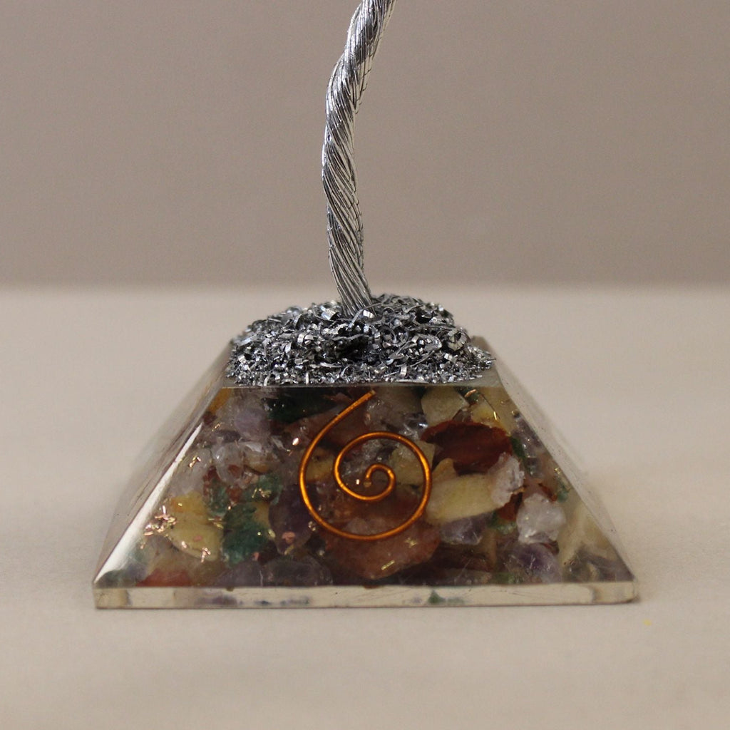 Pyramid-shaped crystal with a spiral design on a neutral background