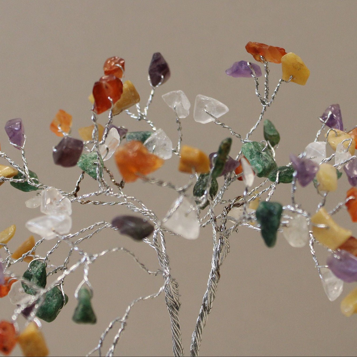 Decorative branch with multicolored stones on a plain background