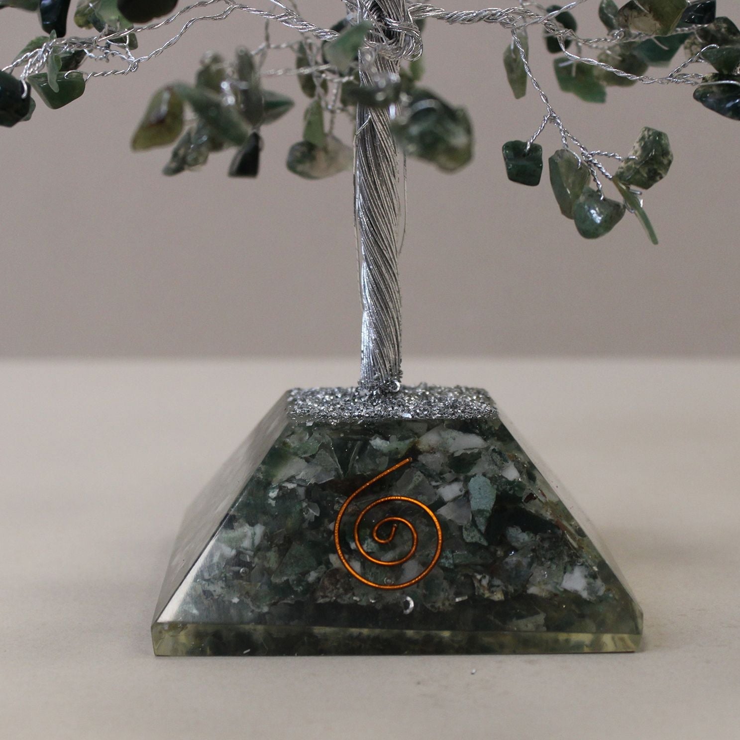 Decorative stone pyramid with a spiral design on a neutral background
