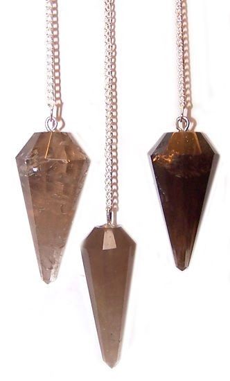 Three crystal pendulums on chains against a white background