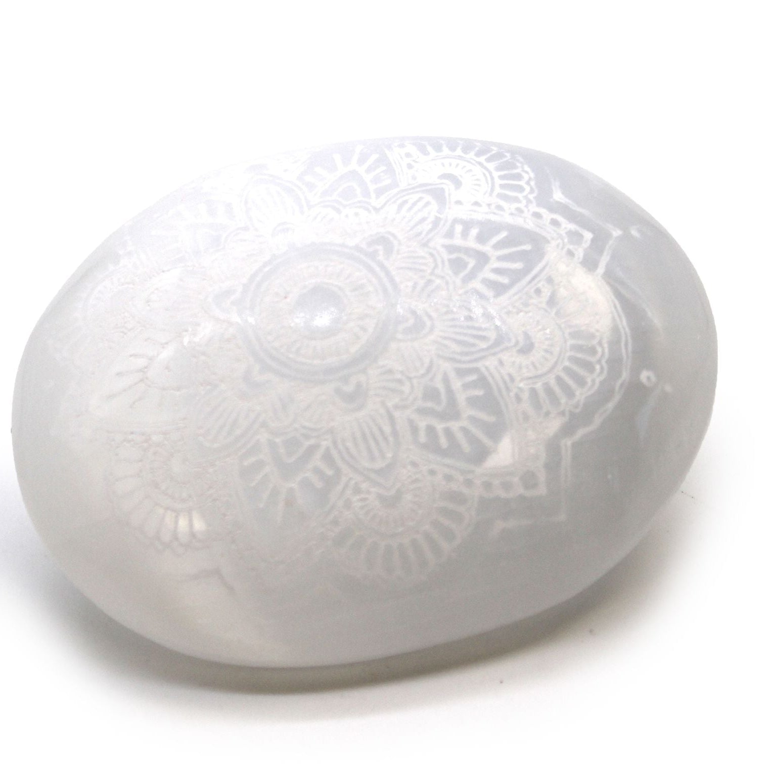 Round white object with embossed design on a white background