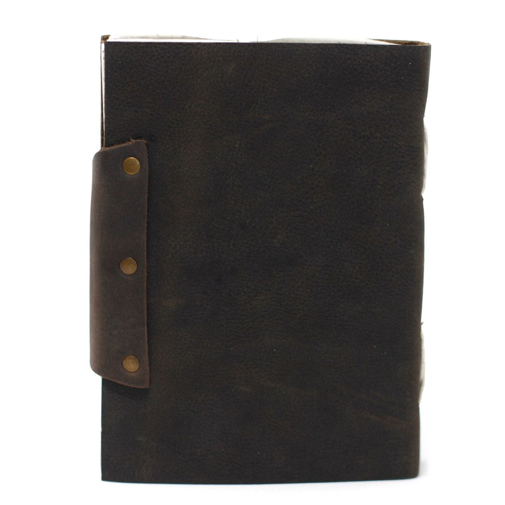 Black leather notebook with brown strap and brass fasteners on a white background